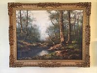Full view of framed oil painting showing wooded landscape with water and signature.