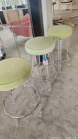 Three barstools side by side on carpet with mirror reflection