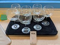 Six Baccarat crystal wine glasses arranged on black cloth, each about 8 inches tall.