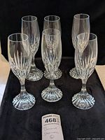 Six cut crystal stemware displayed on black cloth with auction tag visible