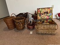 Various assorted baskets displayed on carpet, including wicker baskets and a wire basket