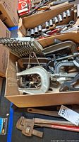 Box with assorted metal clamps including C-clamps, sockets and socket wrench bits, hand tools and miscellaneous items.