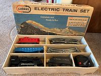 Full view of Lionel electric train set inside original box showing train cars, tracks, and transformer.