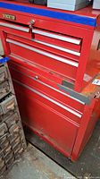 Side view of two-piece red metal tool chest set with visible rust and peeling paint