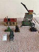 Full set of pre-war 1940s metal train accessories on carpet