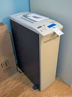 Photo showing the full view of the tall Fellowes 120C-2 paper shredder unit with its gray and black body and control panel on top.