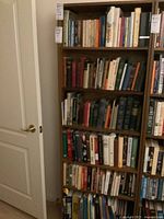 View of case unit with six shelves full of assorted books covering multiple subjects and genres.