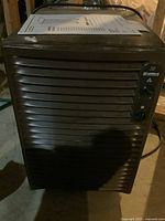 Front view of brown Kenmore 38 dehumidifier showing overall body with horizontal air vents and power cord at top.