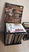 Photo showing black plastic crate filled with approximately 55 LP records, topped with the Liszt/Brahms and Juse Greco albums.
