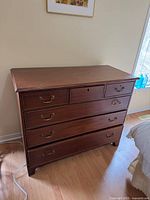 Front view of chest of drawers showing drawer arrangement and metal pulls