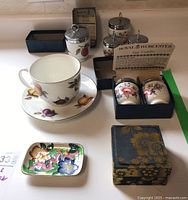 Overview of all items including two Royal Worcester egg coddlers in boxes, large Staffordshire cup and saucer, and floral Maling trinket dish.