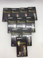 Front view of nine boxed EMTEC T-60 VHS Professional tapes with one in foreground, showing sealed packaging