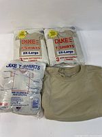 Front view of three sealed packs and one shirt laid out