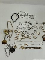Full layout of assorted rings, necklaces, brooches, bracelet, chains on white background