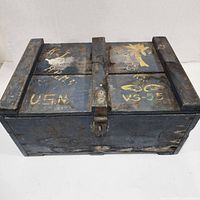 Front view of the vintage US Navy wooden crate showing the hinged lid and metal latch with hand-painted markings including U.S.N and VS-55.