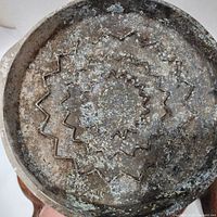 Bottom of a cast iron skillet showing embossed star pattern and signs of use and patina.