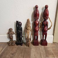 Group photo of five wooden carved figures showing sizes, colors, and details.