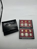Two 1980 U.S. Proof Sets in original plastic cases and two black outer boxes.