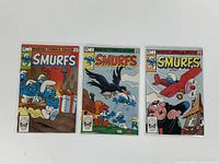 Three Smurfs comics in protective bags and boards, showing front covers with colorful illustrations and Marvel Comics Group branding.