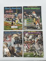 Top down view of all four Sports Illustrated magazines in plastic sleeves showing covers.