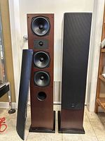 Front view of both tower speakers, one grille removed