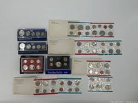 Full lot overview showing 12 mixed U.S. Proof Sets in various packaging, including envelopes and plastic holders.