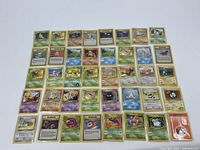 Full display of 40 English and Japanese Pokémon cards in penny sleeves laid out in rows showing both Pokémon and Trainer cards.
