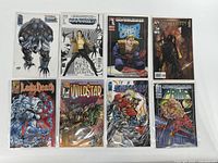 Top view of all eight comic books displayed in a single row, showing front covers in bags and boards.