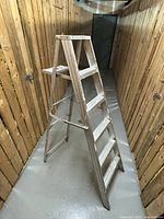 Full view of five foot folding aluminum ladder showing its step configuration and condition.