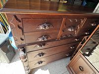 Front and side view of the antique bonnet chest dresser showing carved wood details and multiple drawers