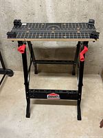 Front view of the Black and Decker Jobmate folding work bench showing its overall structure, measurements on top and clamps.