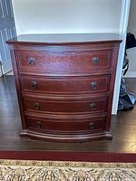 Front view of the Bombay Company dresser showing four drawers and metal handles.
