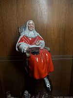 Full front view of Royal Doulton The Judge figurine showing seated judge in detailed red robe and wig