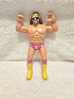 Front view of the Macho Man Randy Savage LJN action figure, showing detailed muscular build, sunglasses, yellow boots, maroon trunks, and wristbands.