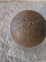 Shotput ball showing the '4 KG' weight stamped on its surface with a rough, metallic texture.