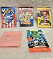 Photo of four assorted trading card wrappers - Superman III, Wrestling Wrestlemania III, Garbage Pail Kids Series 1, Teenage Mutant Ninja Turtles movie cards