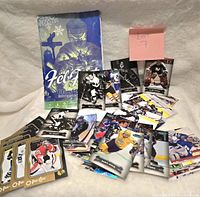 Wide view of hockey autograph trading cards spread on a light surface with a blue hockey themed box marked Feb 9 1998 in the background