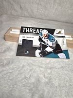 Joe Thornton hockey patch card showing player image, patch piece, and Panini logo, on light background