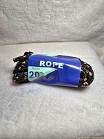 Photo showing the black rope with braided design wrapped with a blue label stating 'ROPE LENGTH 20 FT.'