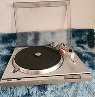 Front angled view of Sony PS-T22 turntable with tonearm resting, platter with rubber mat, and clear plastic dust cover in raised position.