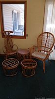 Set of 5 wicker furniture pieces against wall including two chairs, round side table, and two footstools.