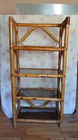 Front view of bamboo 4 tier shelving unit showing overall structure, smoked glass shelves, and bamboo frame details.
