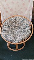 Image of papasan bowl chair with floral cushioned seat in front view.