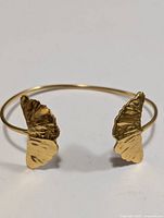Front view of gold tone butterfly cuff bracelet showing both butterfly ends.