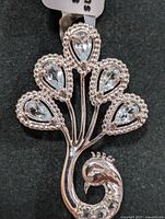 Front view of silver pendant with five pear-shaped blue topaz stones and beaded silver edging
