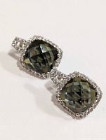 Front close-up view of one earring showing cushion-cut gemstone with checkerboard facets, halo of smaller clear stones, and silver setting with loop connector.