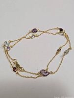 Photo showing the entire necklace loosely arranged to display chain and gemstone spacing.