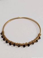 Silver bangle bracelet with multiple smokey quartz beads hung along one side, shown from top view