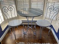 Full front view of round bistro table and two matching chairs