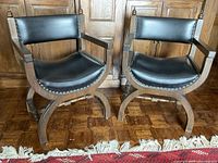 Two barrel chairs shown together in front of wooden cabinet